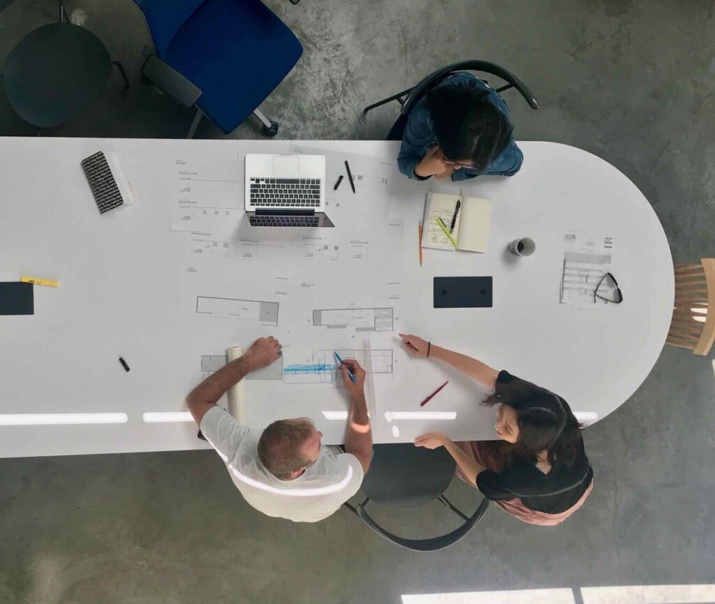 Blueprints and architectural plans on a large conference table.