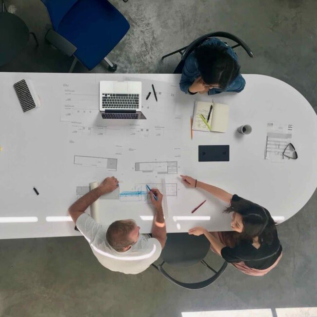 Blueprints and architectural plans on a large conference table.