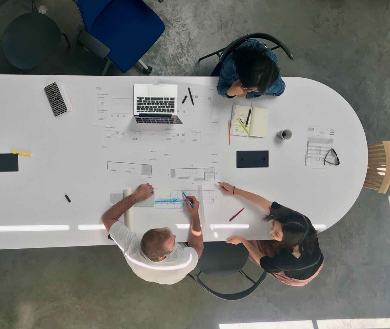 Blueprints and architectural plans on a large conference table.
