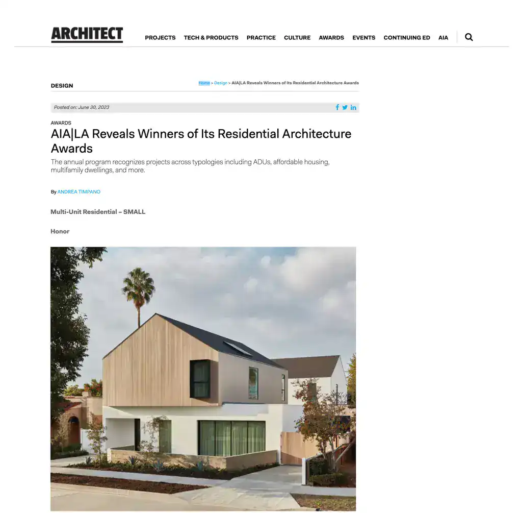 Modern residential house with a mixed material facade, featuring wood and stucco exterior, angular roofline, and large windows, set in a landscaped suburban environment.
