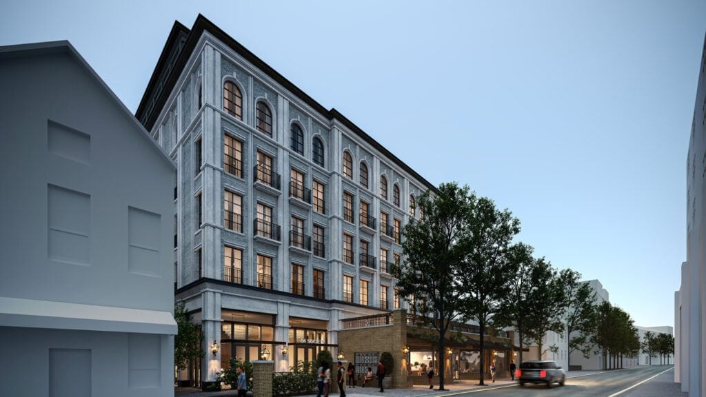 Elegant multi-story building with classic architectural details and arched windows, illuminated warmly from within.