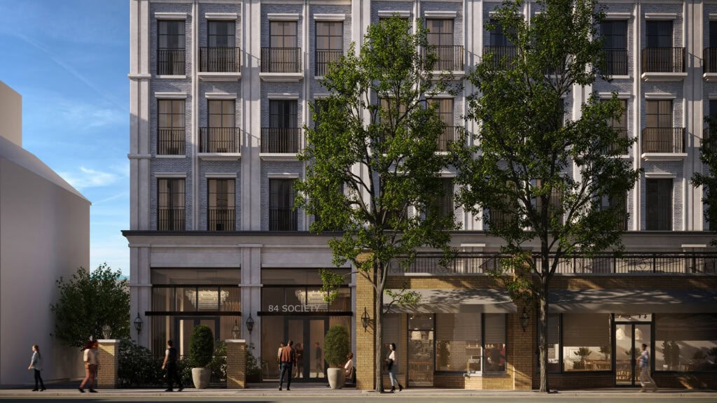 Luxurious brick and stucco facade with tall windows and small balconies, modern commercial ground floor with large glass storefronts.